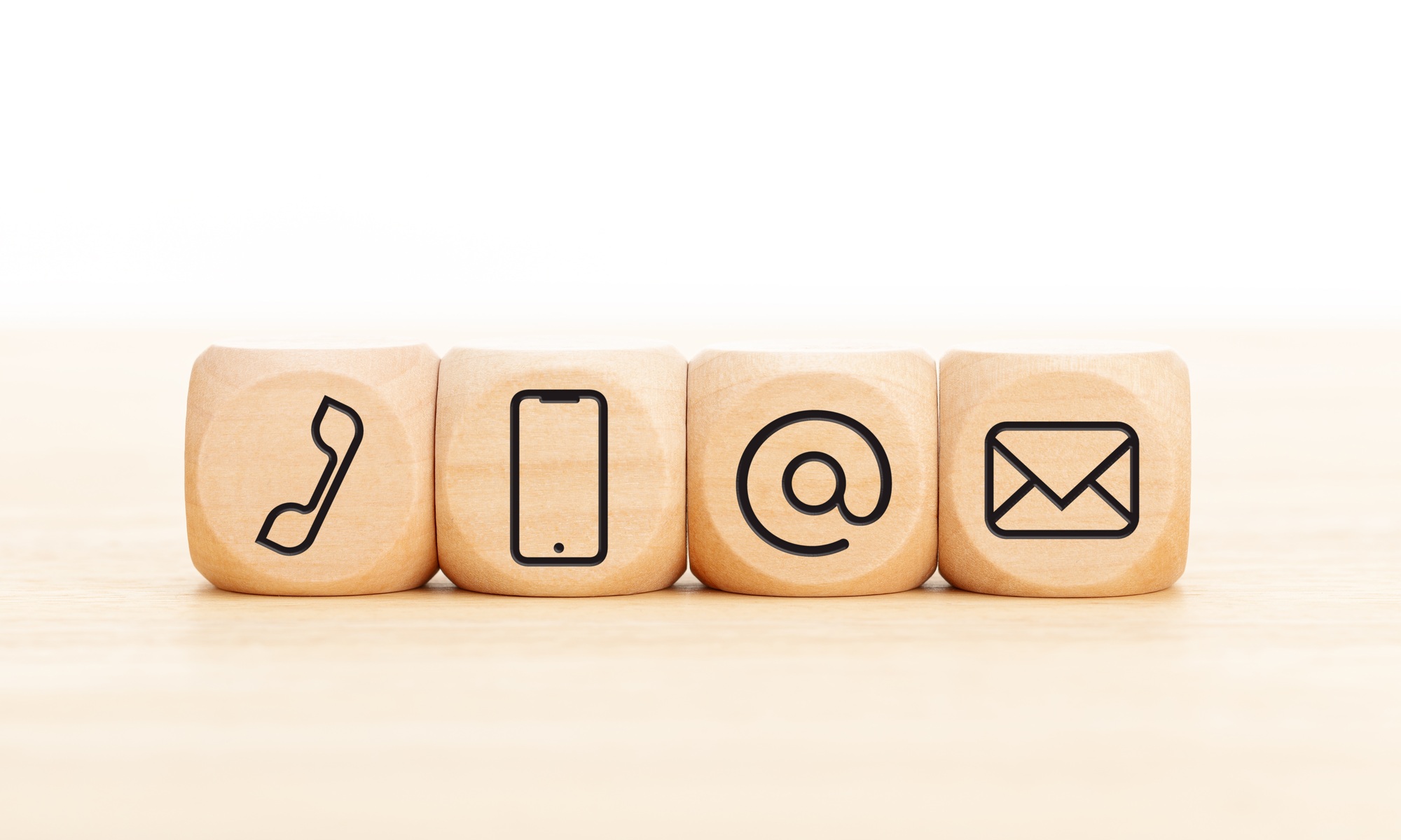 Contact us icons in wooden blocks on wooden desk
